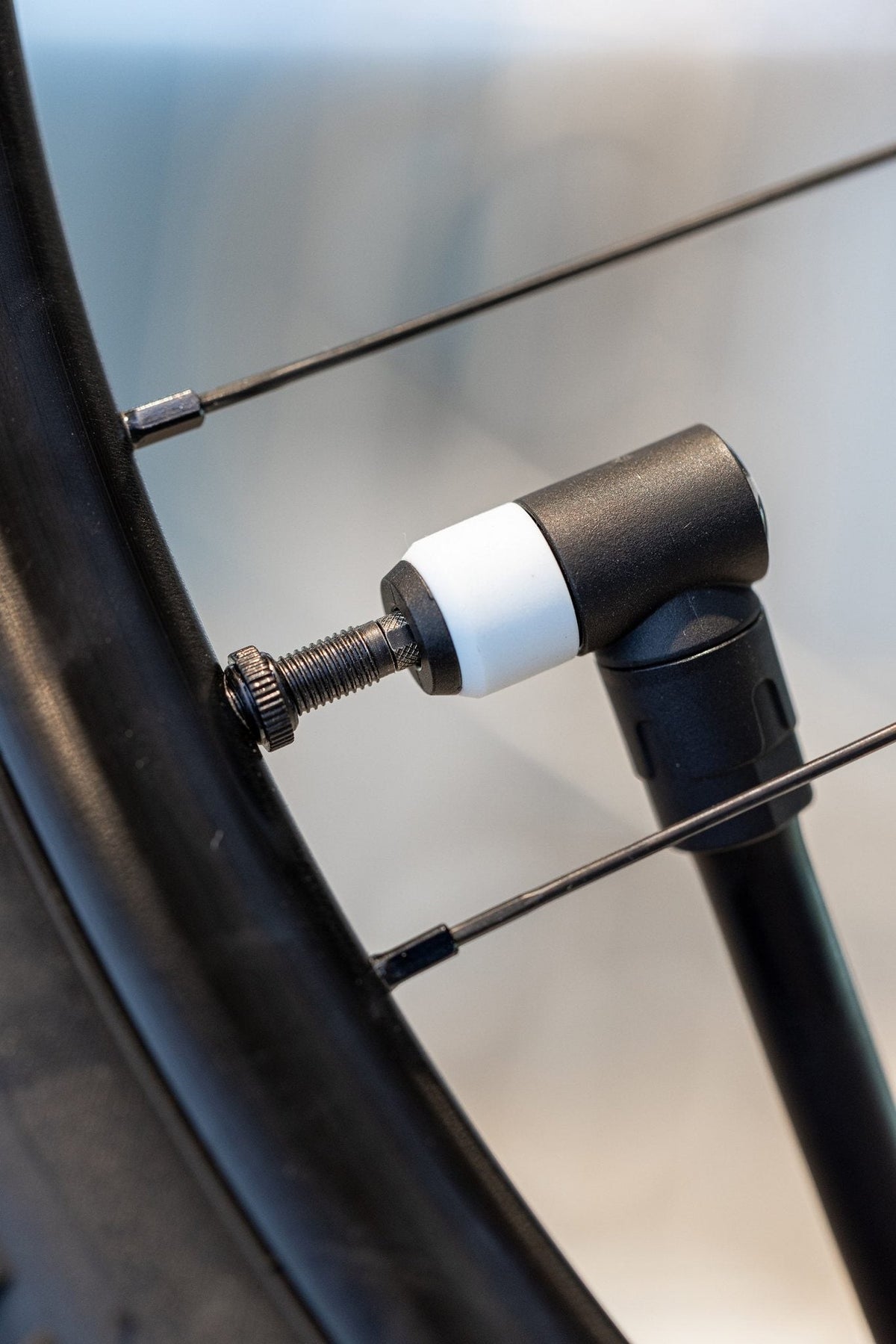 Detailaufnahme des Schwalbe Clik Valve Systems: Eine Fahrradpumpe ist per Klickadapter mit einem Presta-Ventil verbunden.